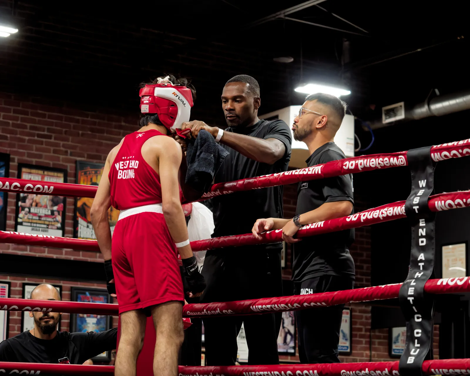 A West End coach checks a fighter's headgear at Friday Night Fights VIII